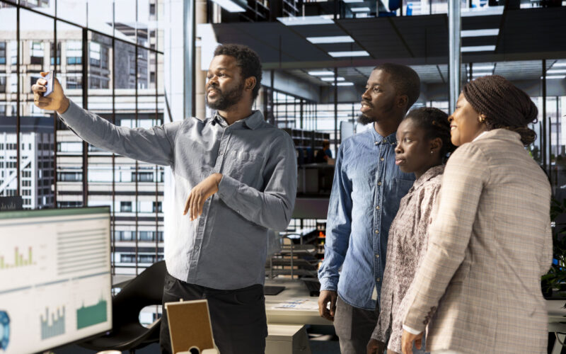 Smiling african american team taking photos at the corporate office, having fun and laughing around on webcam. Business coworkers making memories and enjoying a break, collaboration.